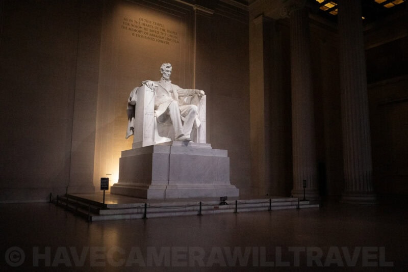 Lincoln Memorial statue lit inside its columned hall viewed from a low angle at night