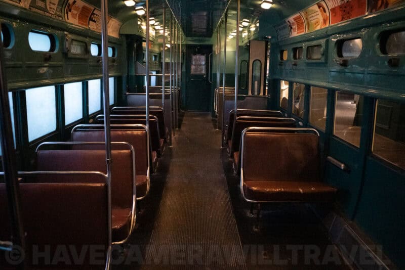 Vintage transit railcar interior with empty seats and dim overhead lighting