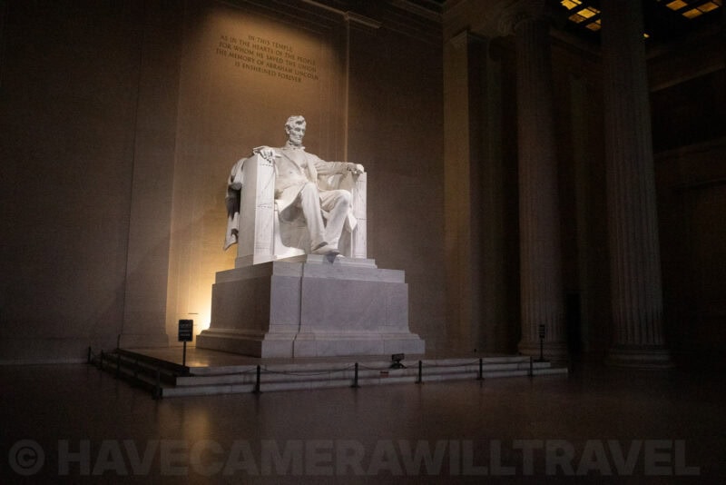 Lincoln Memorial statue illuminated at night within its marble colonnaded chamber