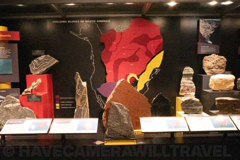 Museum exhibit of rock specimens beside a colored map of North America's geology