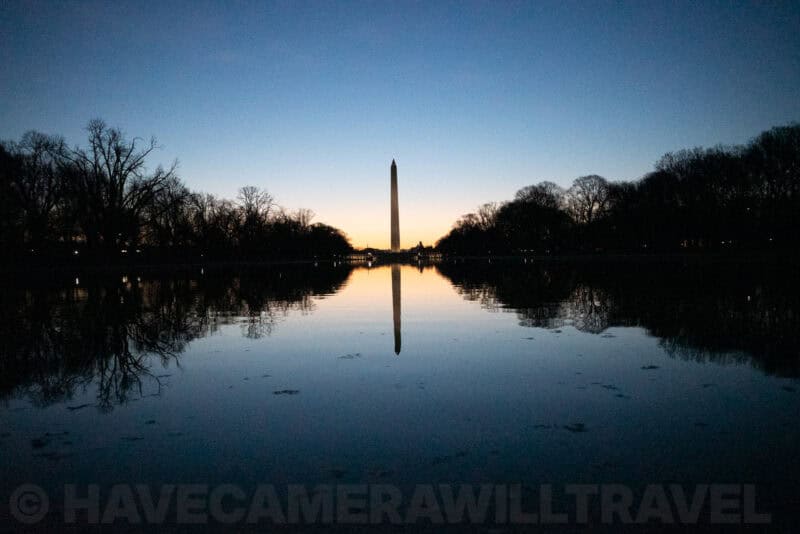 Washington Monument silhouette reflected in the still Reflecting Pool at dusk