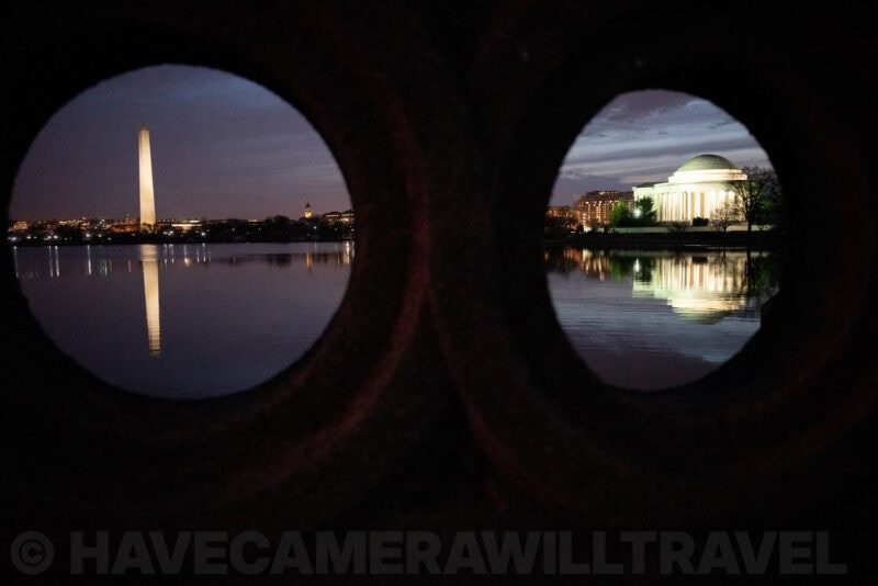 Washington Monument and Jefferson Memorial framed through two dark circular openings at night