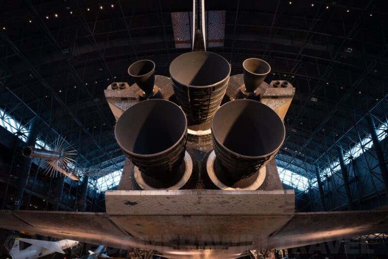 Space shuttle's engine nozzles viewed from below inside a museum hangar