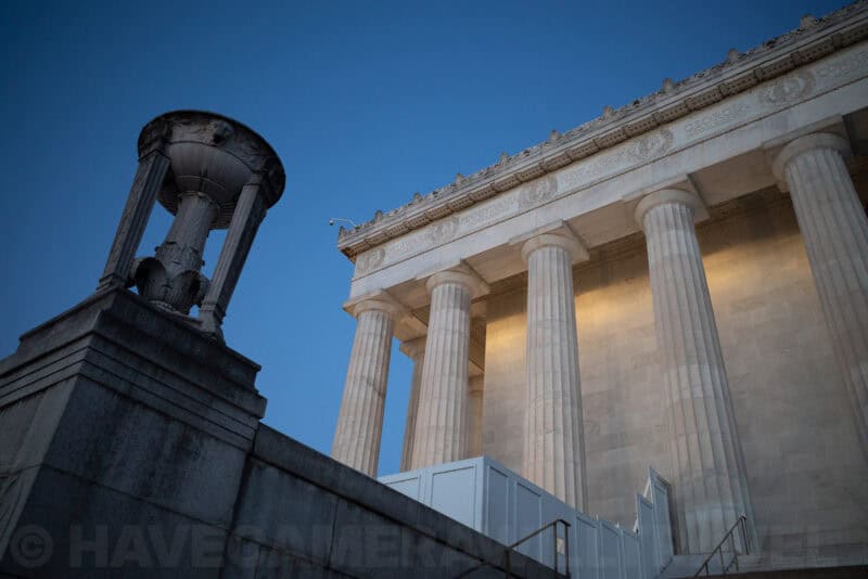 Lincoln Memorial columns and cornice lit at dusk beside an ornamental lamp