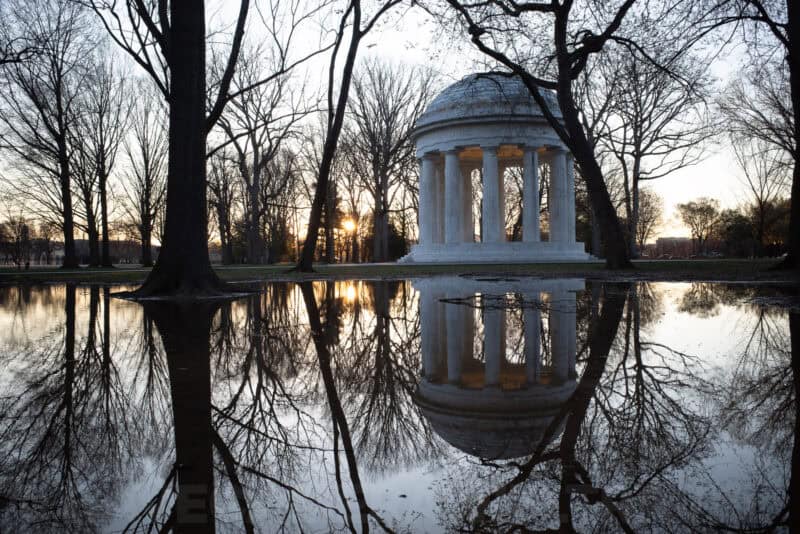 District of Columbia War Memorial rotunda reflected in a still pond at dusk