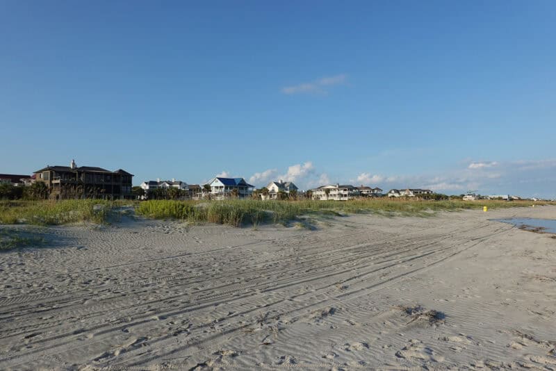 Sandy beach with distant row of coastal houses shot at 24mm wide angle