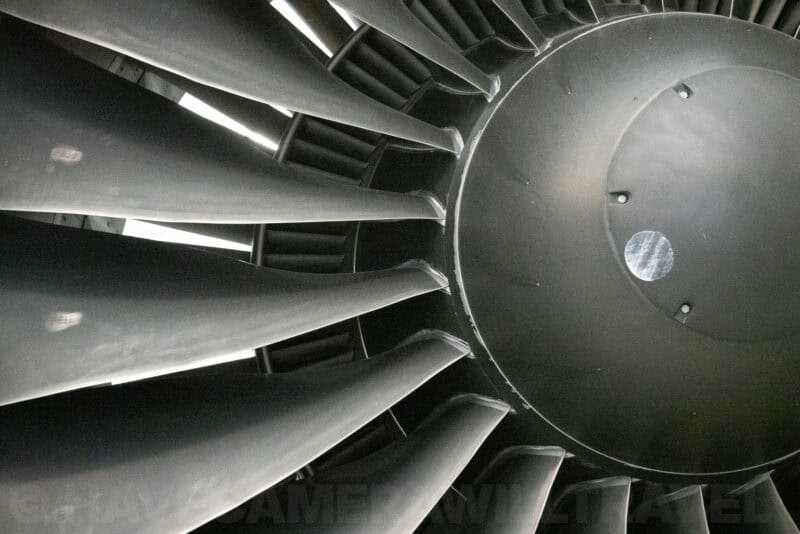 Jet engine fan blades and metal hub shown in close-up detail inside an aviation museum