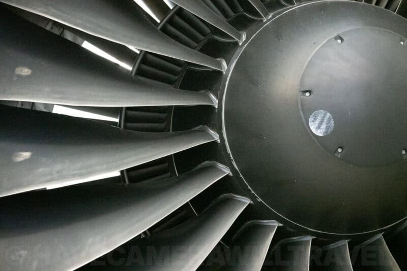 Detailed close-up of curved turbine fan blades and central hub of a jet engine