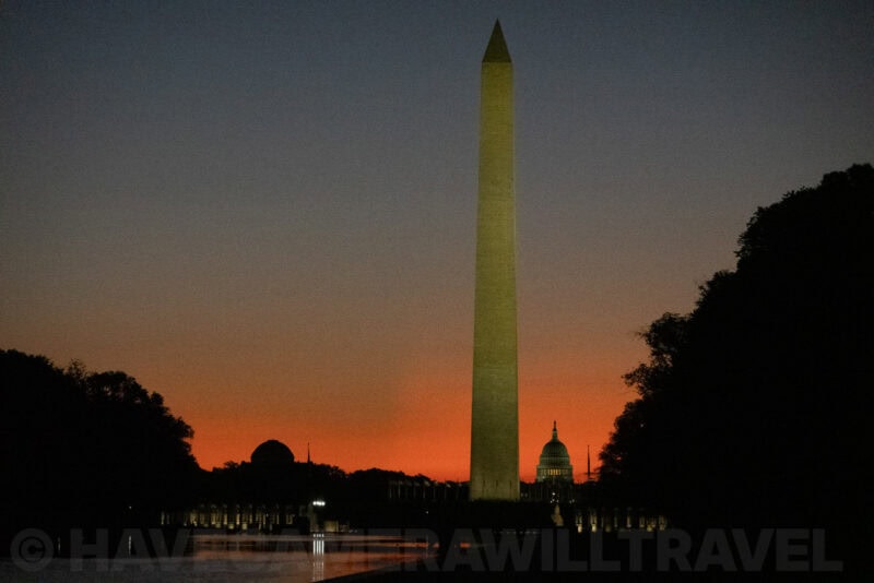 Washington Monument silhouetted with the Capitol building visible against a deep orange sunset
