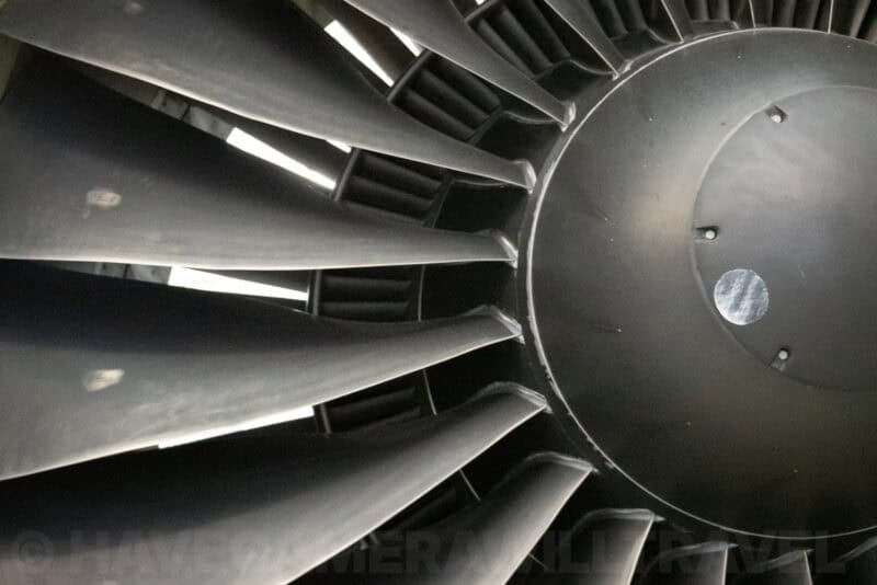 Close-up of a jet engine's turbine fan blades and metal hub inside an aircraft display