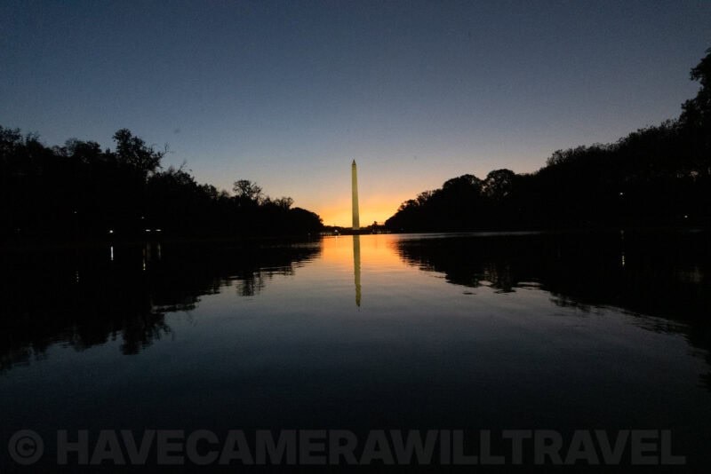 Washington Monument and its reflection in the calm Reflecting Pool under a fading sunset sky