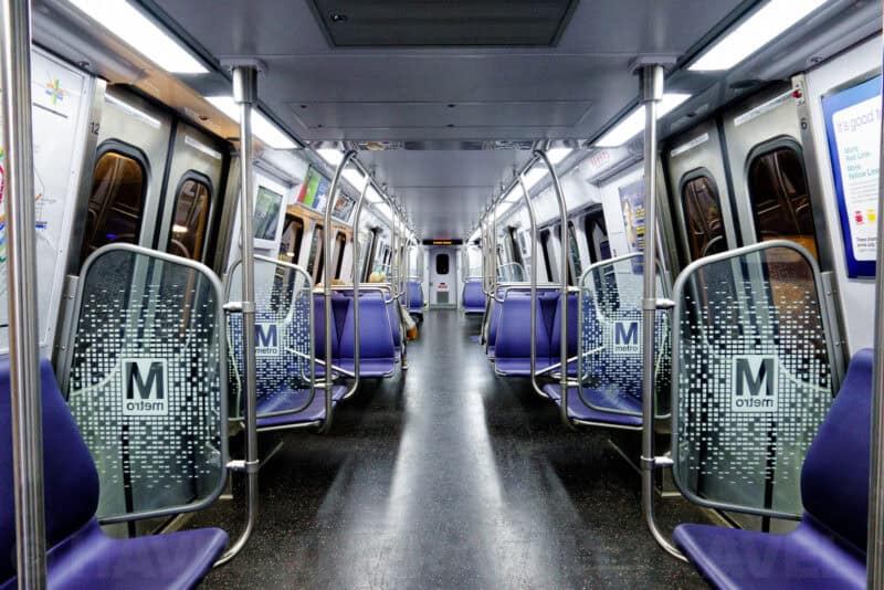 Empty Washington DC Metro train car interior with purple seats and metro-branded doors