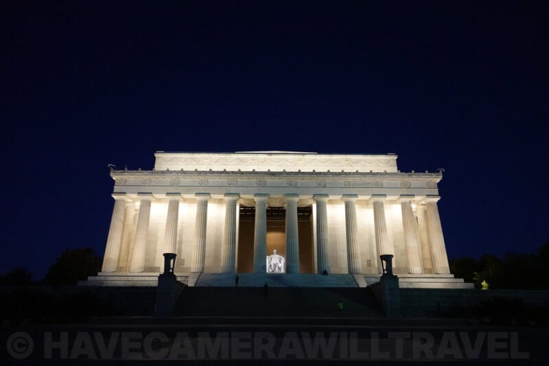 Lincoln Memorial illuminated at dusk with its columned facade glowing against dark blue sky