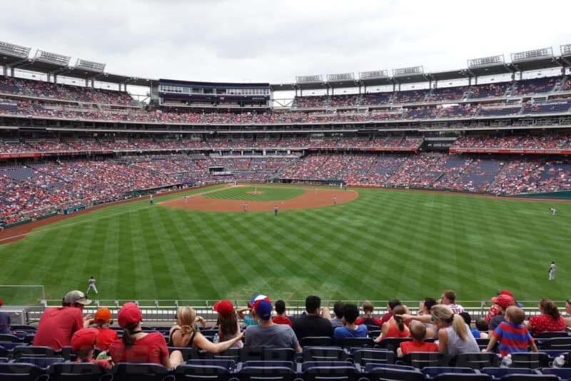 Baseball stadium infield and packed stands viewed from behind home plate seating