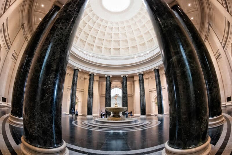 Dark marble columns framing the domed fountain rotunda of the National Gallery of Art