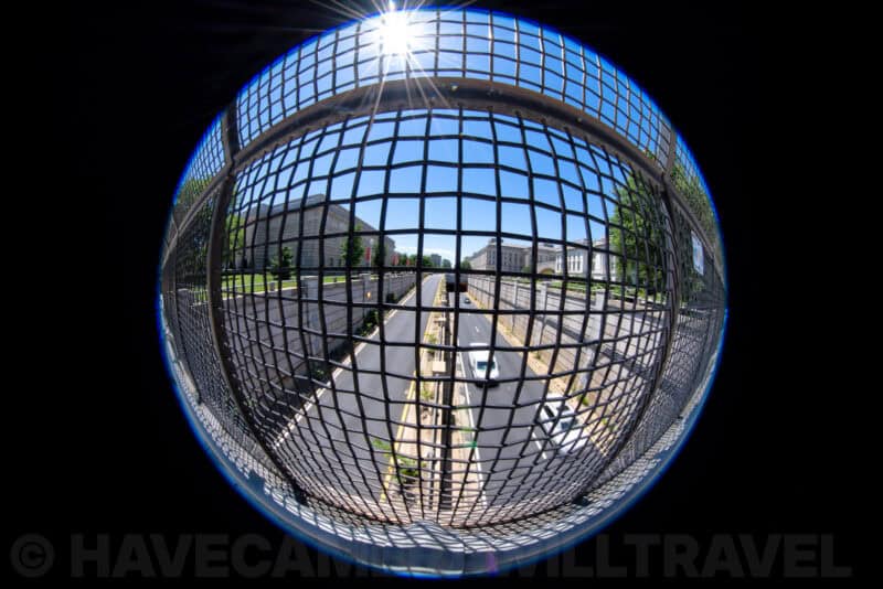 Fisheye view through a wire safety net looking down a Washington DC avenue toward government buildings