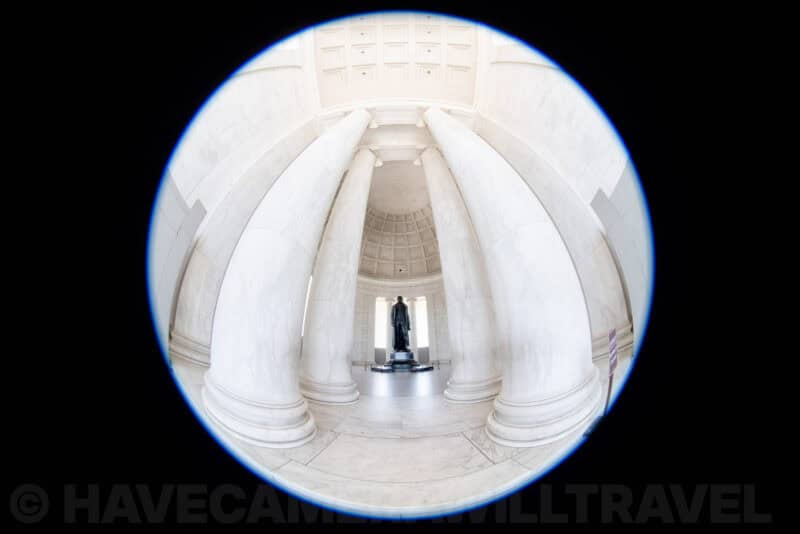 Circular fisheye view through marble columns toward the statue inside the Jefferson Memorial