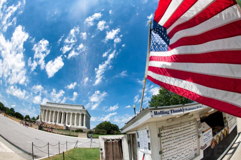 Lincoln Memorial seen across the National Mall beside a Rolling Thunder flag stand and American flag