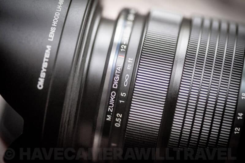 M.Zuiko 12-40mm f/2.8 PRO II lens with focus ring pulled back, exposing manual focus distance scale
