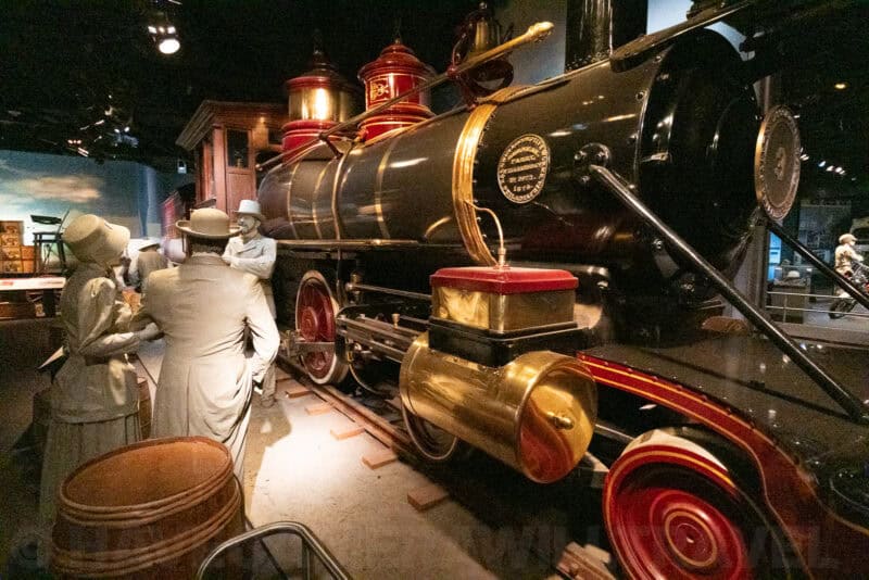 Restored black and gold vintage steam locomotive with mannequins in period dress, ISO 51200 sample