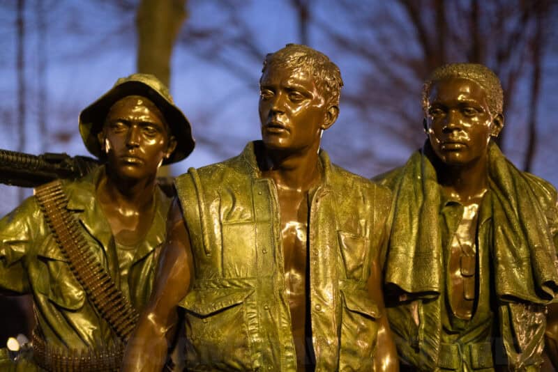 Close-up of the bronze soldiers in the Three Servicemen statue at the Vietnam Veterans Memorial at dusk