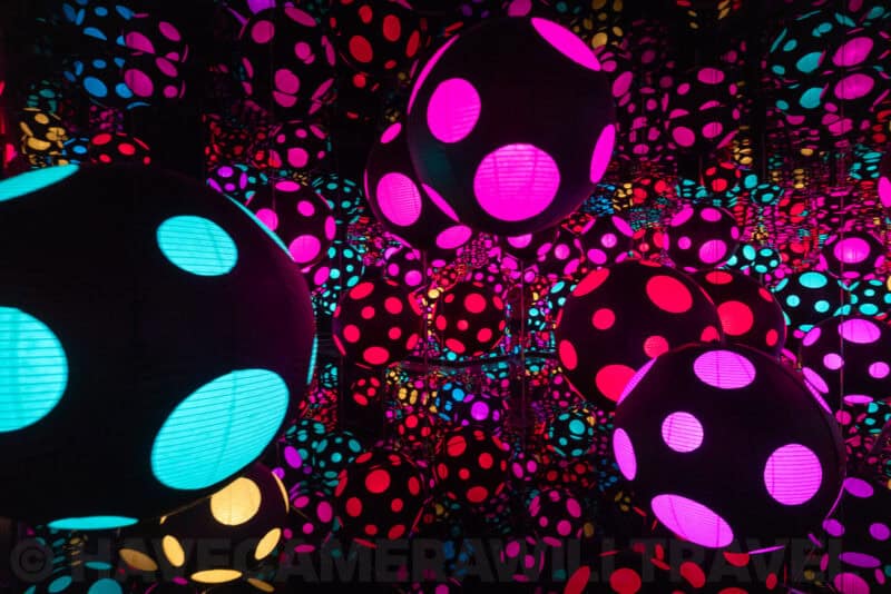 Immersive polka-dot mirrored room with glowing spotted spheres in pink, cyan and yellow