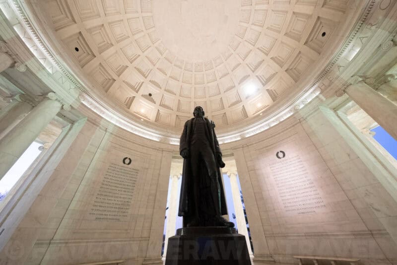 Jefferson Memorial statue viewed from below inside the coffered dome, columns framing engraved wall text