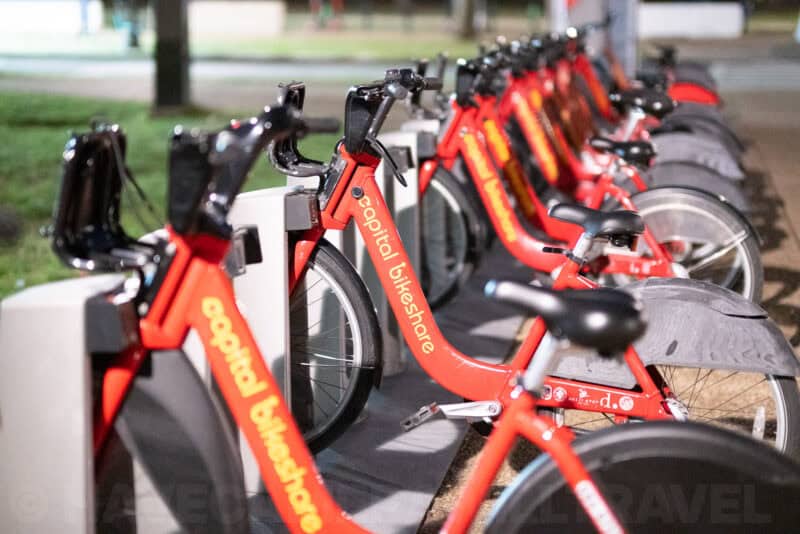 Row of red Capital Bikeshare bicycles docked at a station in Washington D.C. at night