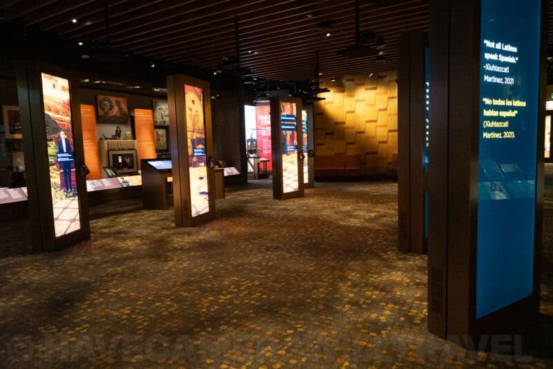 Museum exhibition hall with illuminated display panels and patterned carpet flooring