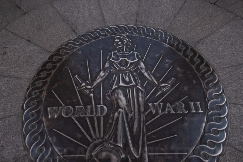 Bronze World War II Memorial plaque with relief figure and lettering reading WORLD WAR II