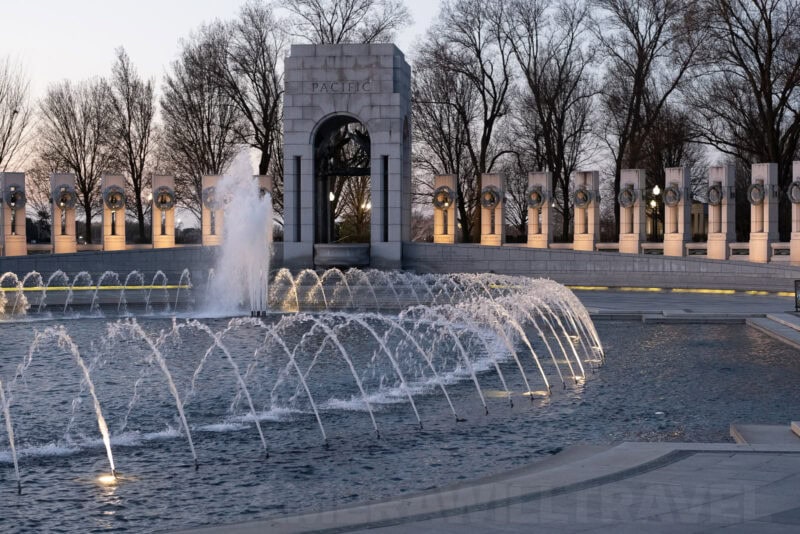 Fountains spraying in the arcs at the National World War II Memorial's Pacific pavilion at dusk