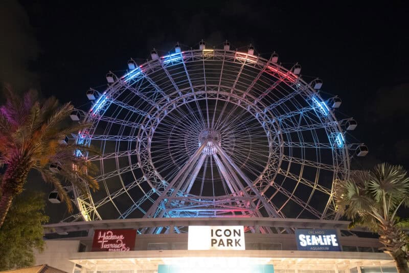 Illuminated Ferris wheel at ICON Park in Orlando glowing with colorful lights at night