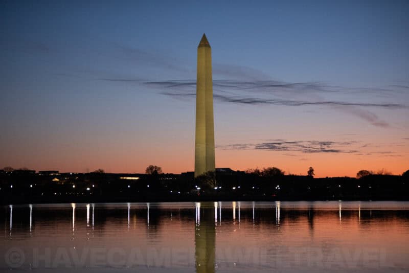 Washington Monument reflected in the Tidal Basin at dusk under a fading orange sunset