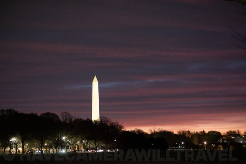 Washington Monument silhouetted against a vivid pink and purple sunset sky
