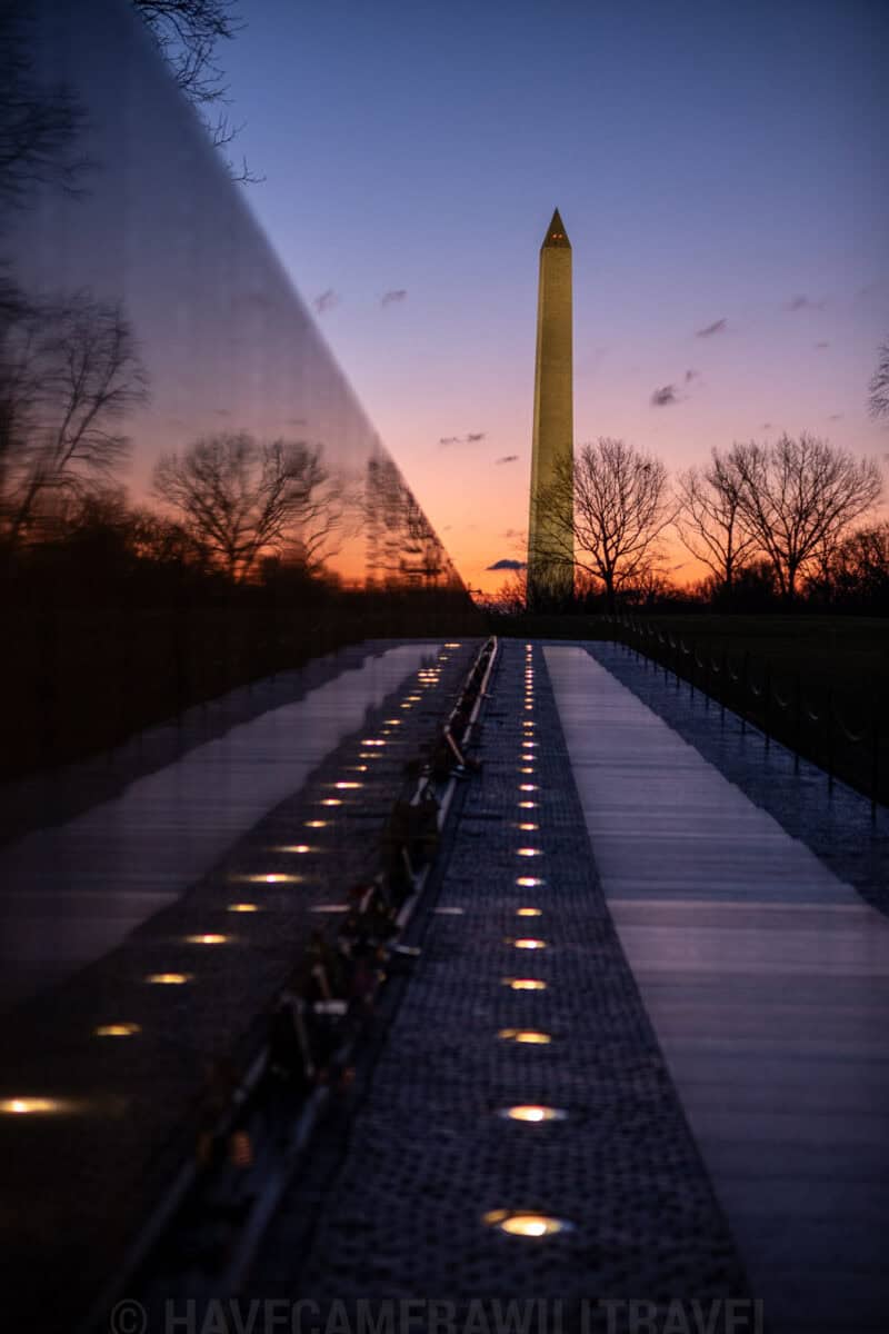 Vietnam Veterans Memorial wall reflecting the Washington Monument at sunset