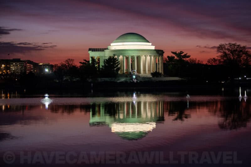 Jefferson Memorial dome lit up at dusk with its reflection in the Tidal Basin