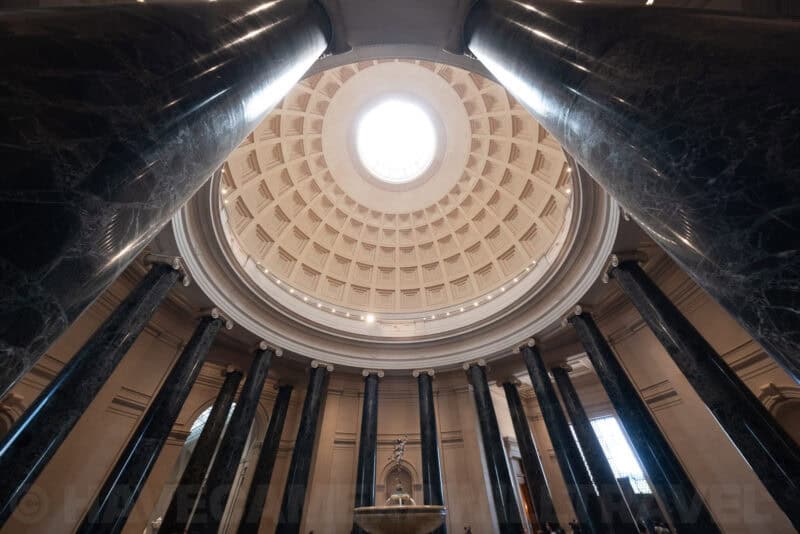 Coffered dome and dark marble columns fanning out inside the National Gallery of Art rotunda