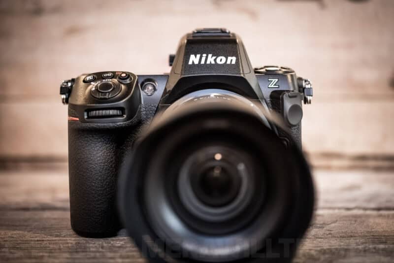 Front view of a Nikon Z8 mirrorless camera with lens facing the camera, mounted on a wooden surface