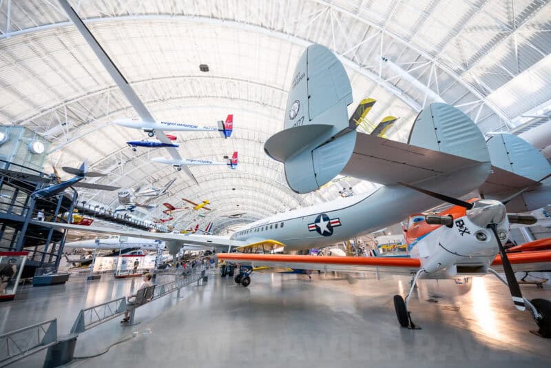 Vintage aircraft suspended and displayed under the curved hangar roof of the Udvar-Hazy Center
