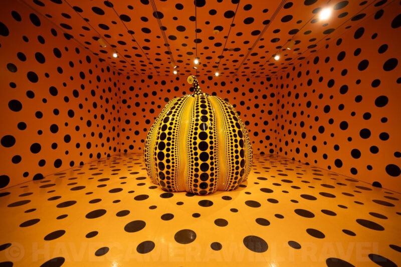 Yayoi Kusama polka-dot pumpkin sculpture inside an orange and black dotted infinity room