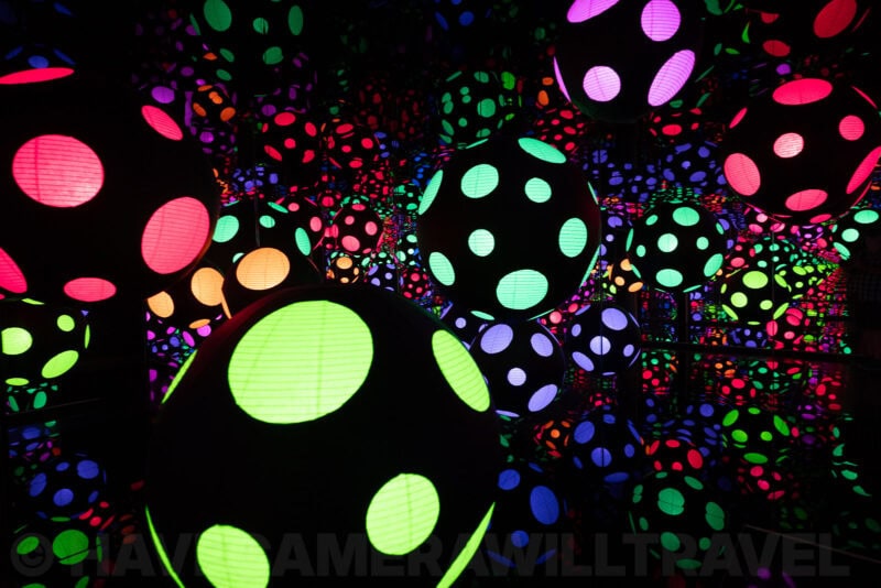 Glowing polka-dotted spherical lanterns in a dark immersive light art installation