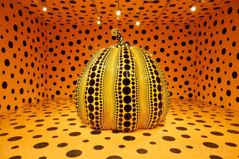 Yayoi Kusama's polka-dot pumpkin sculpture inside a mirrored orange infinity room