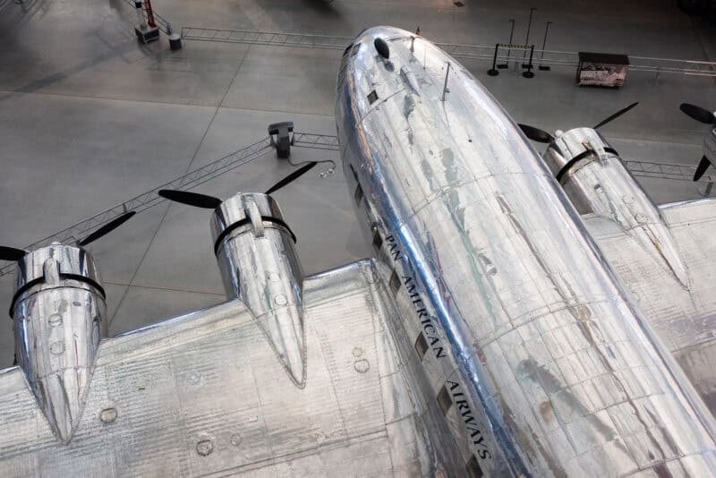 Vintage silver Pan American Airways propeller plane fuselage viewed from above in a museum hangar