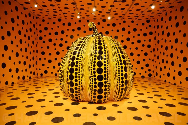 Yayoi Kusama polka-dot pumpkin sculpture displayed inside a mirrored, dot-patterned room