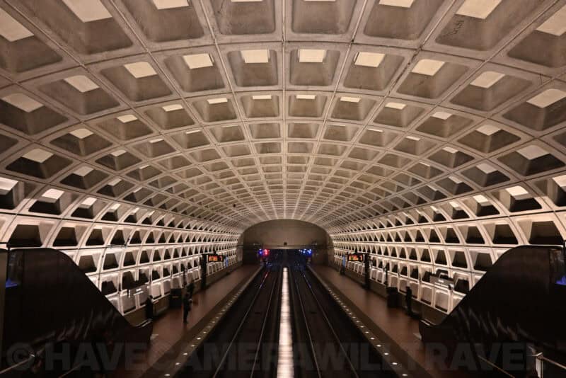 Symmetrical view down a Washington DC Metro platform under its arched waffle ceiling