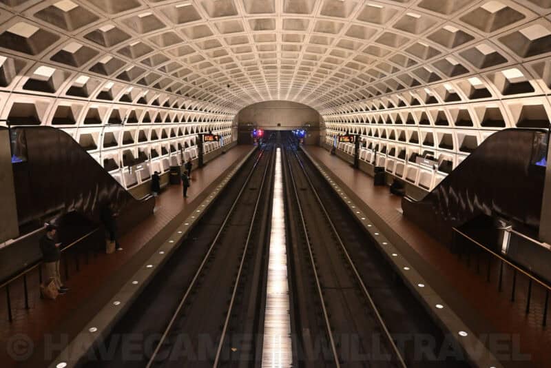 Symmetrical coffered concrete ceiling of a Washington DC Metro station viewed down the platform