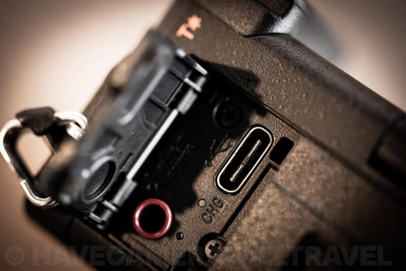Close-up of the Sony a6700's USB-C port labeled CHG next to the camera's strap lug