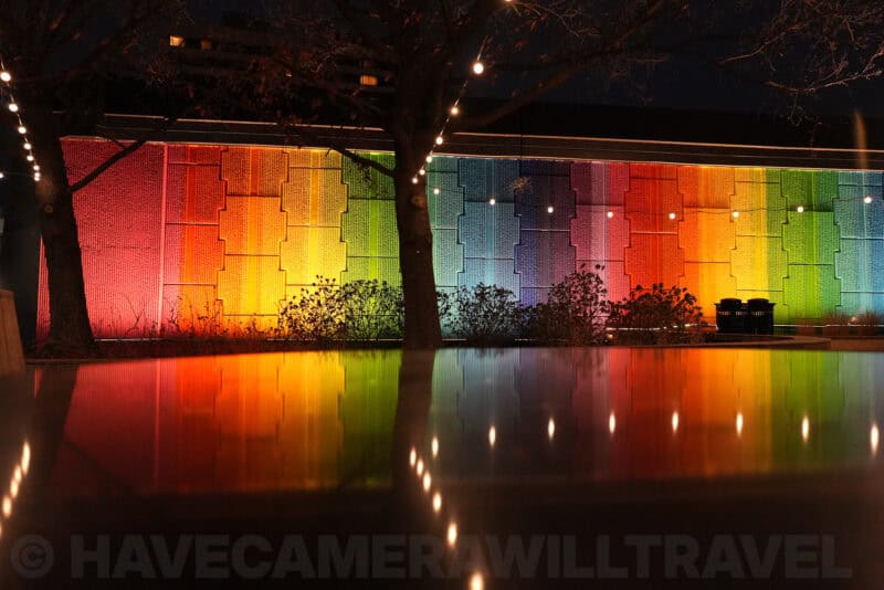 Rainbow-lit wall reflected in water at night with bare trees, ISO 3200 low-light sample