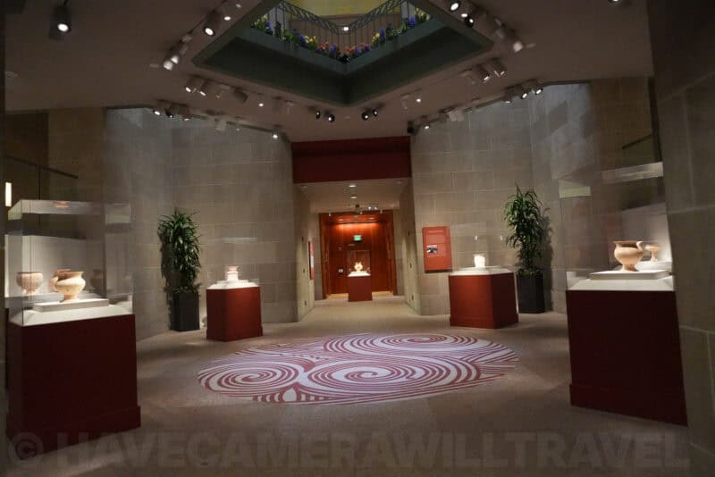 Museum display room with ancient pottery on red plinths, ISO 6400 low-light sample