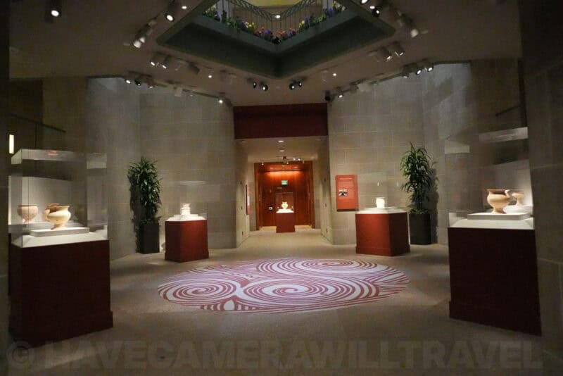 Dim museum hall with pottery displays and patterned floor, ISO 25600 noise sample
